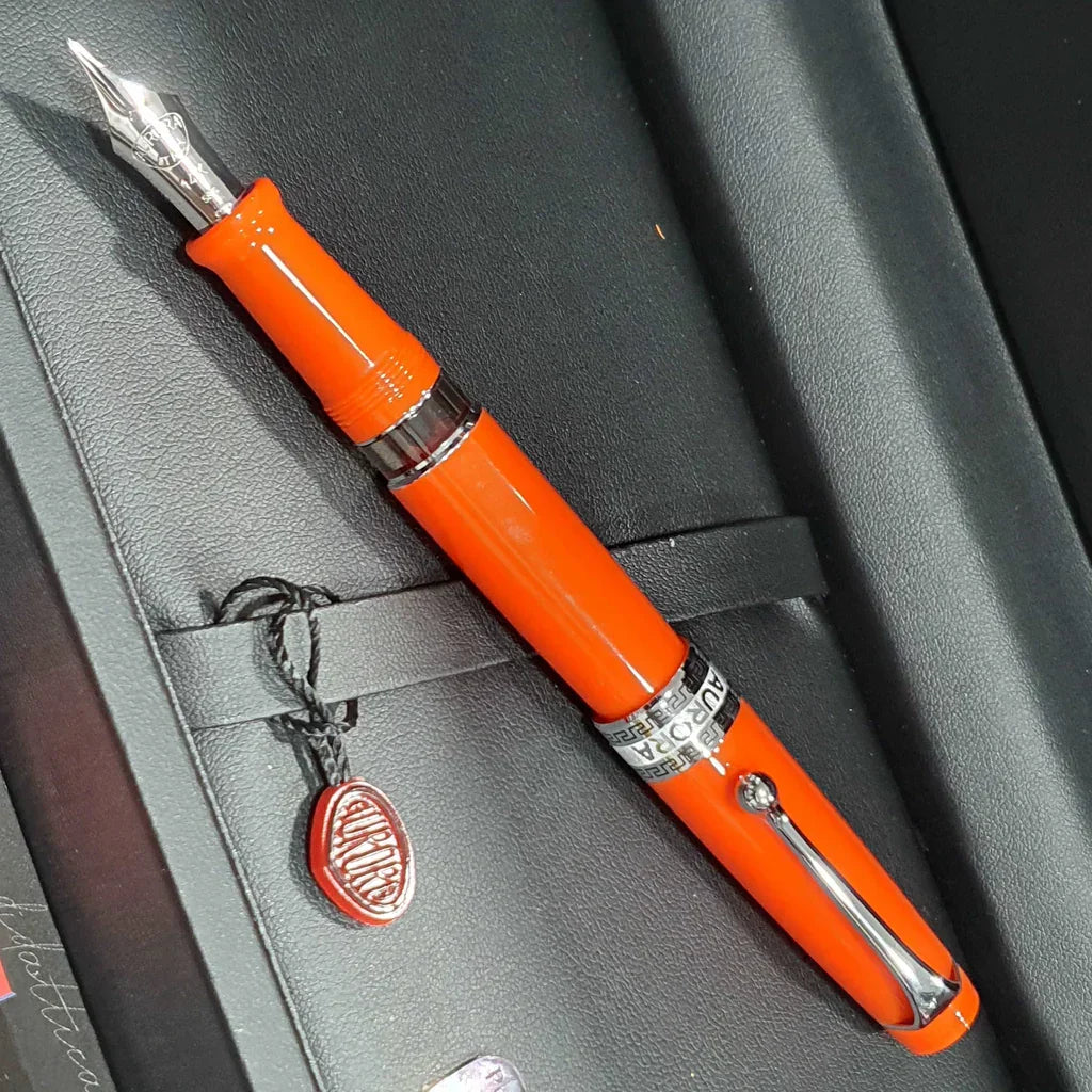 Orange fountain pen with silver clip and nib in a black gift box